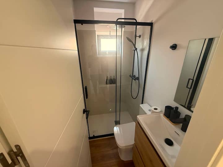 Baño con mueble de lavabo y espejo: agua caliente a cualquier hora.