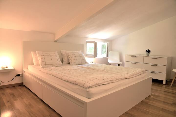 Acogedora recámara en el piso superior con una cama tamaño queen, tocador, estantes y espacio de almacenamiento en los cajones de la cama. Techo bajo en algunos lugares. La habitación está equipada con aire acondicionado. Mosquiteros y persianas en las ventanas.