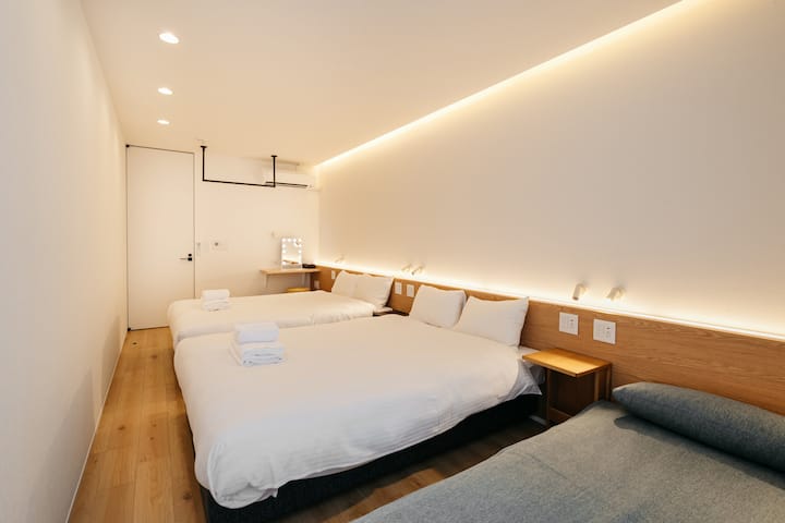 ダブルベッド2台を配した寝室1。間接照明が落ち着いた雰囲気を演出し、ぐっすり眠れる空間です。