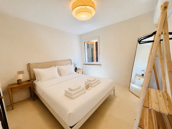 Habitación doble con aire acondicionado, armarios y una ventana con vista al patio interior privado