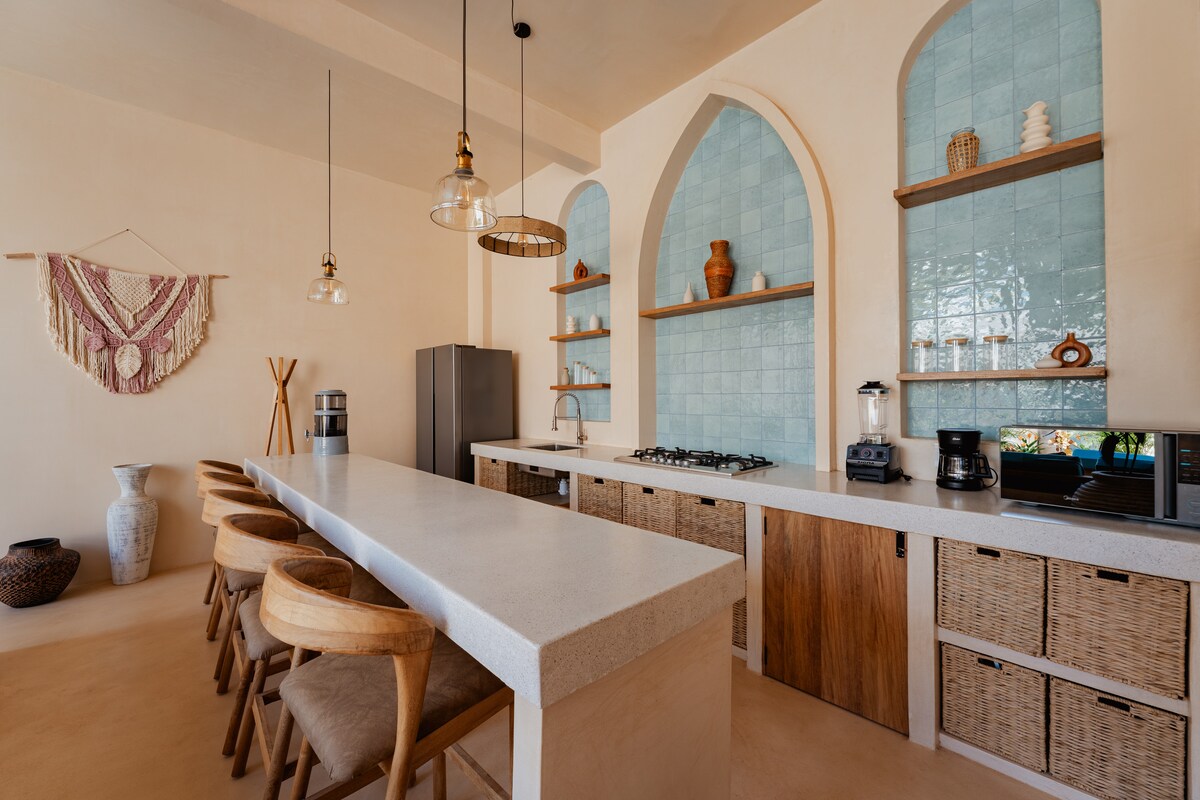Cocina totalmente equipada con electrodomésticos modernos y asientos en la isla.