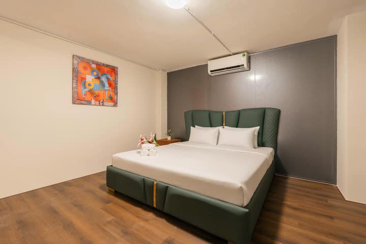 ห้องนอน 2 พร้อมเตียงคิงไซส์ การออกแบบที่ทันสมัยและอบอุ่น โทนสีเขียวมอส – เทา – น้ำตาลไม้ สร้างจุดเด่นที่หรูหรา ผสานกับเตียงหุ้มเบาะคุณภาพสูง แสงไฟนุ่มนวล และพื้นที่ส่วนตัวที่สะดวกสบาย