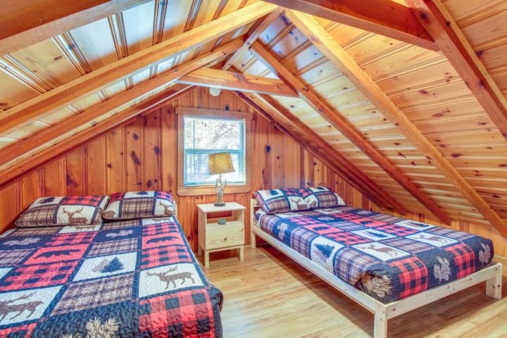 Loft sleeping area (main cabin-upstairs) with two full-size beds and beautiful exposed wood beams.