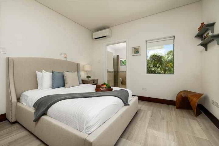 Disfruta de una estadía tranquila en este acogedor dormitorio, que cuenta con una cómoda cama tamaño queen, un amplio armario y hermosas vistas a la piscina y al exuberante jardín. La habitación también ofrece la comodidad de un baño privado en la habitación.