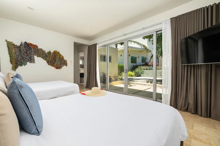 Departamento privado e independiente con jardín, dos cómodas camas tamaño queen, decoración elegante, un diseño espacioso y acceso a través del jardín. Un refugio tranquilo y cómodo con mucha luz natural, comodidades modernas y baño privado en la habitación.