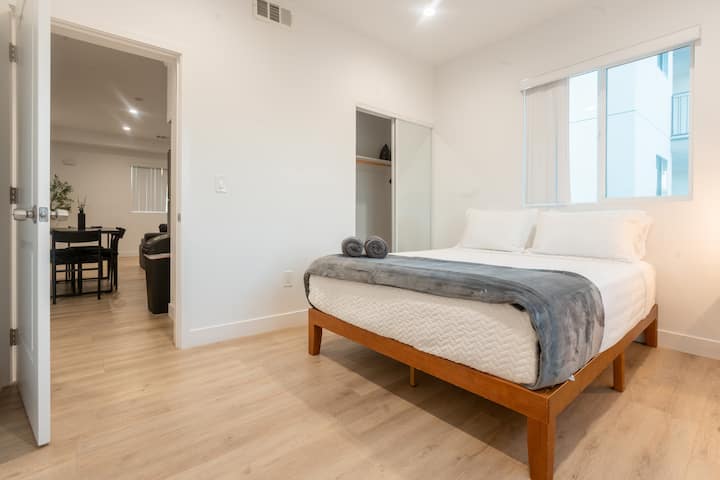 Entrez dans une chambre confortable avec un grand lit, de grandes fenêtres et une salle de bains privée pour un séjour relaxant.