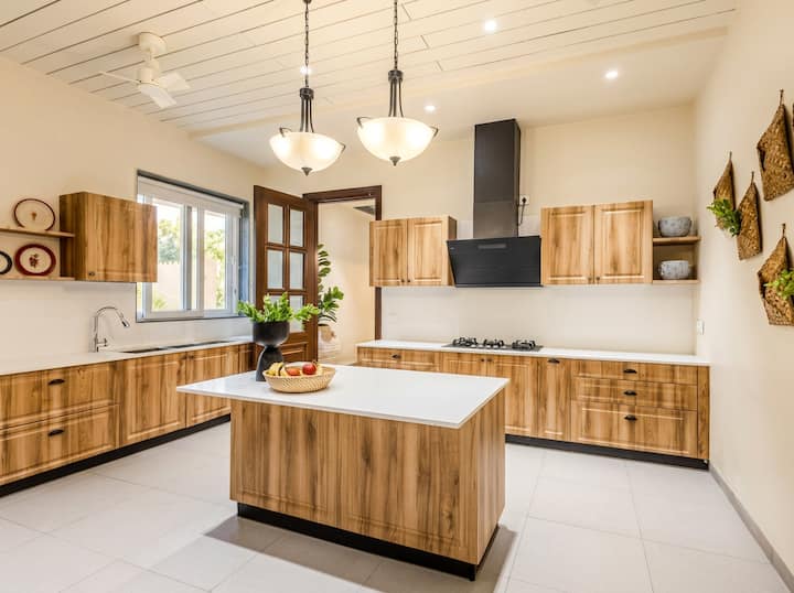 Full kitchen with island, gas hob, and chimney. Yours to use, or hand it to the chef and stay out of it entirely.