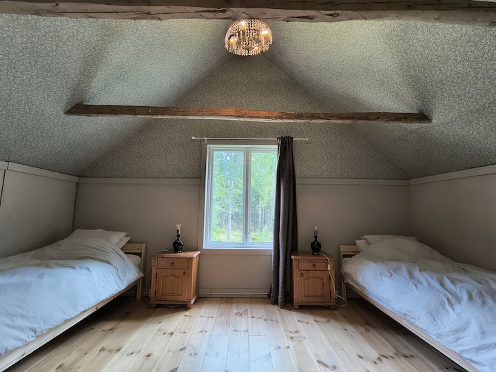 Cette chambre à l'étage dispose de deux lits simples (90 x 200) avec deux oreillers chacun et tous deux avec une couette de 140 x 200.