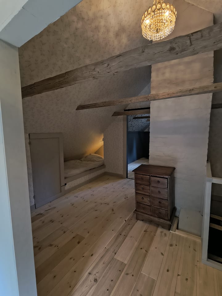 Dans le couloir à l'étage, une alcôve de lit a été construite sous le toit en pente. Idéal pour que les enfants se reposent en paix pendant un moment.