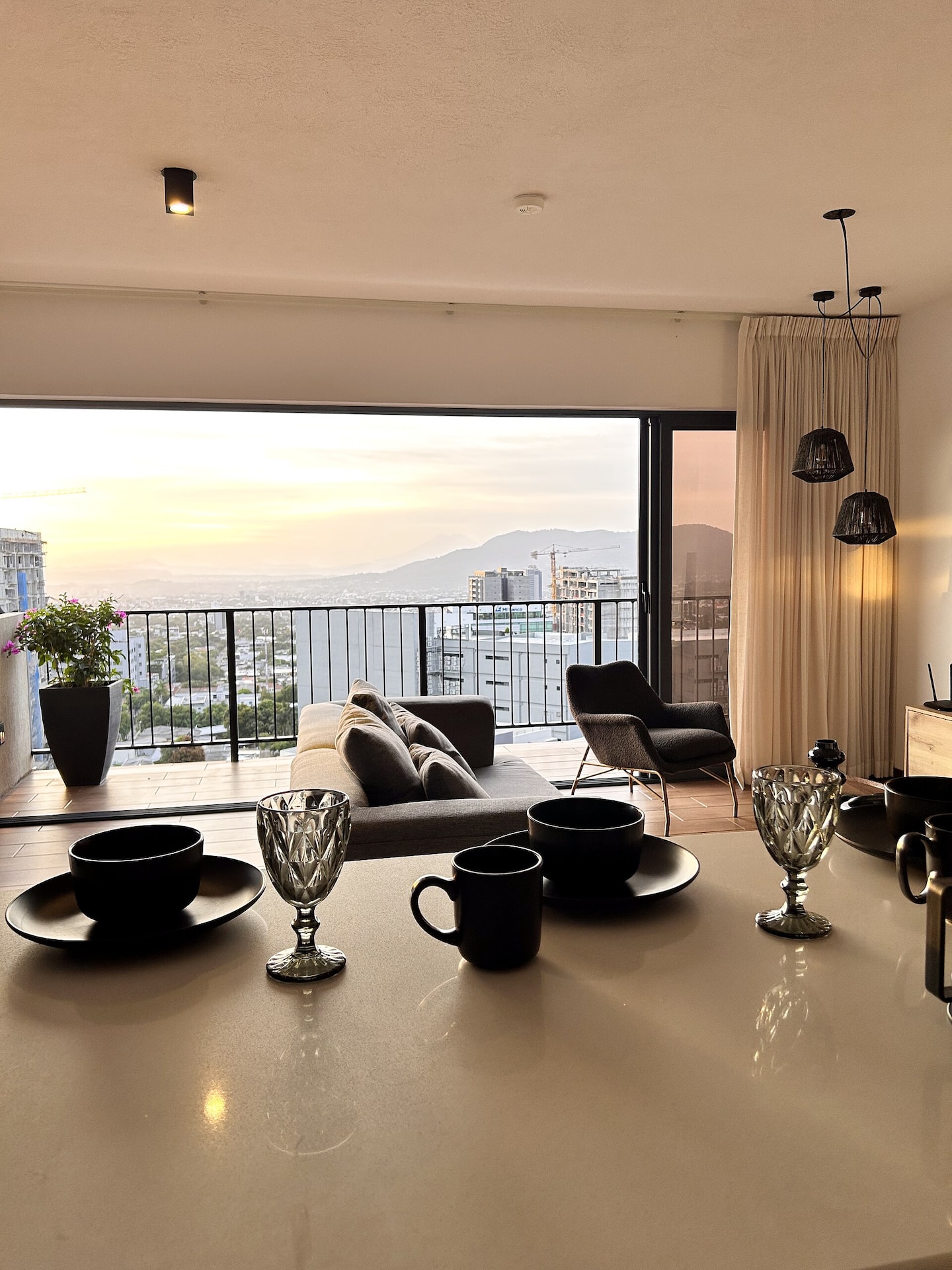 Isla de cocina con vajilla y vista al atardecer a través del ventanal
