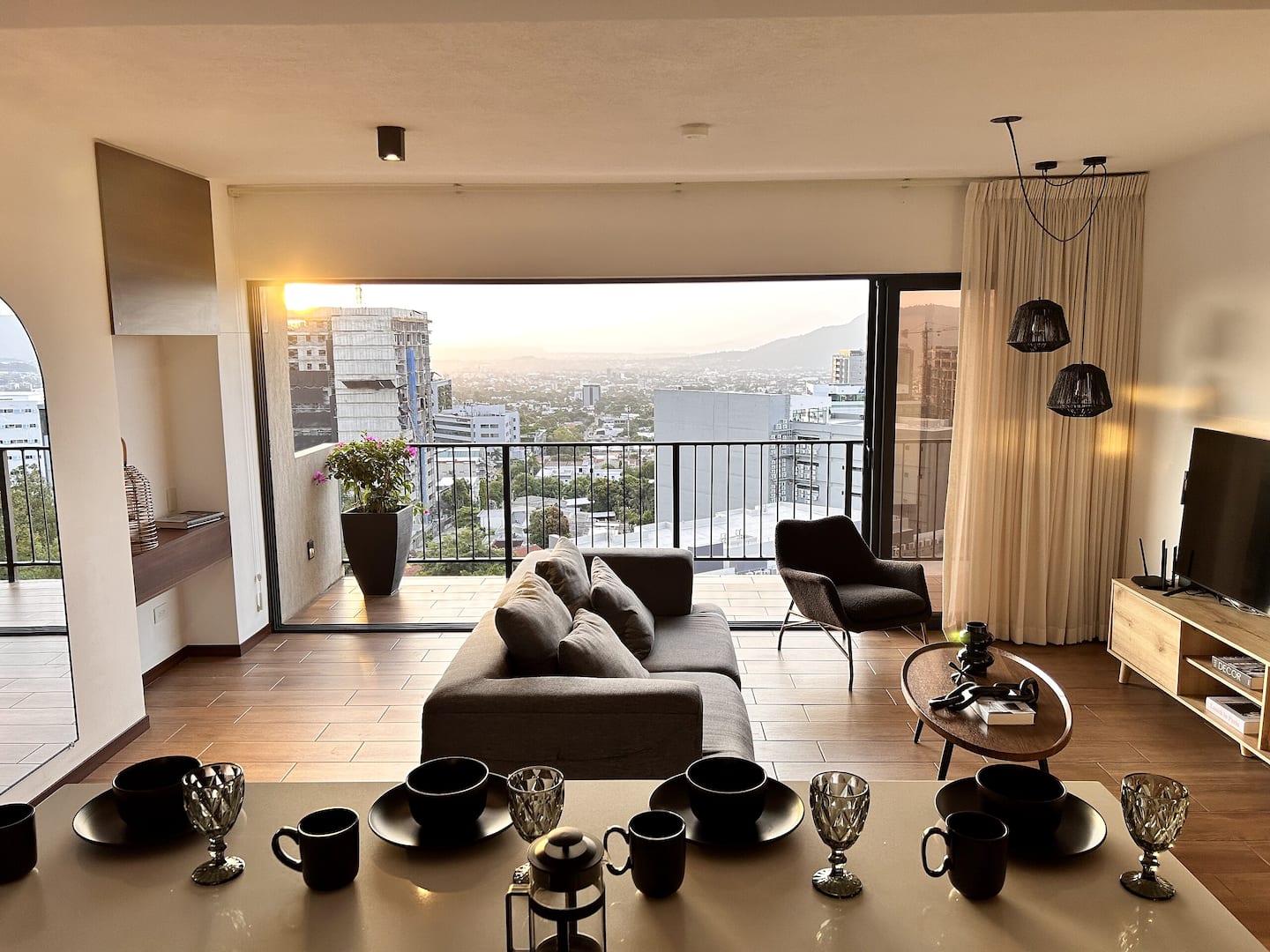 Sala de Casa Zenit con el ventanal abierto hacia el balcón y la ciudad