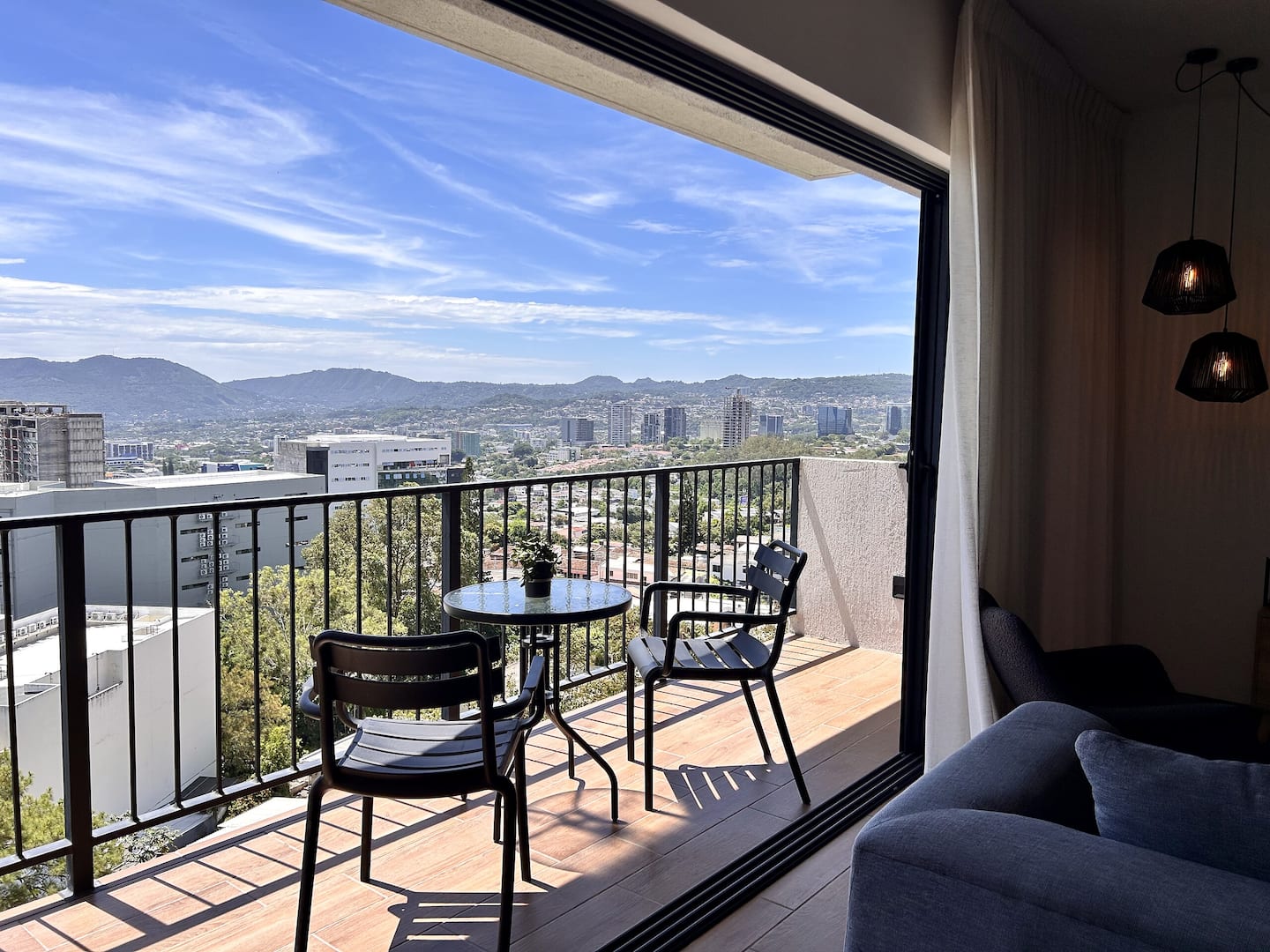 Balcón con mesa para dos y vista a las montañas de San Salvador