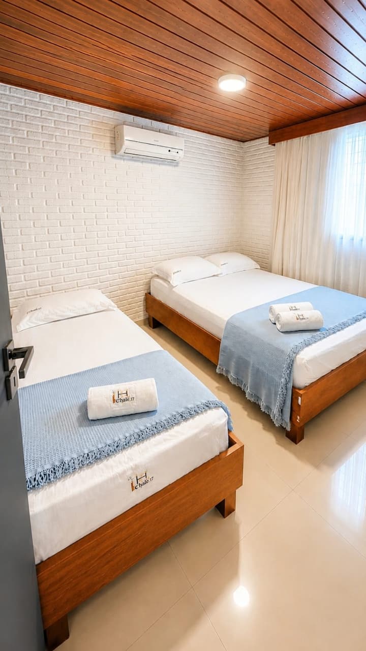 Air-conditioned room with a double bed and a single bed, TV, ideal for families or small groups.
