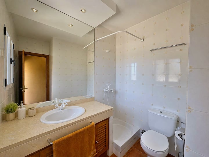 Segundo baño con ducha, lavabo e inodoro, con toallas y artículos de aseo incluidos.