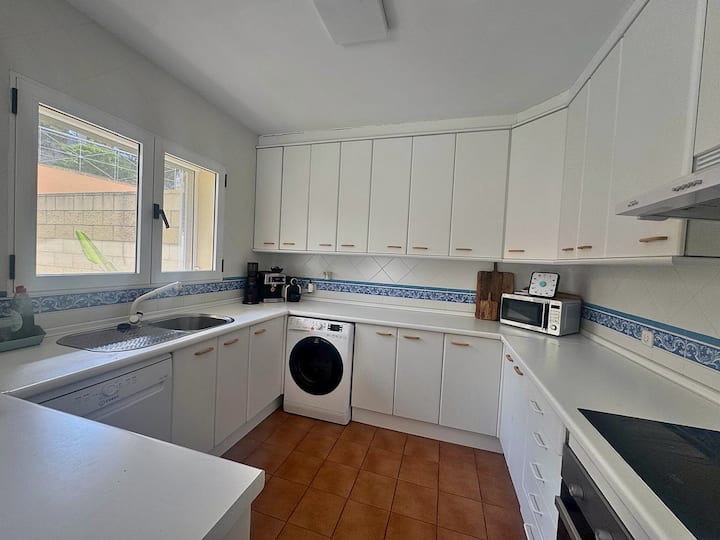 Cocina en U con gran superficie de trabajo y equipamiento completo.