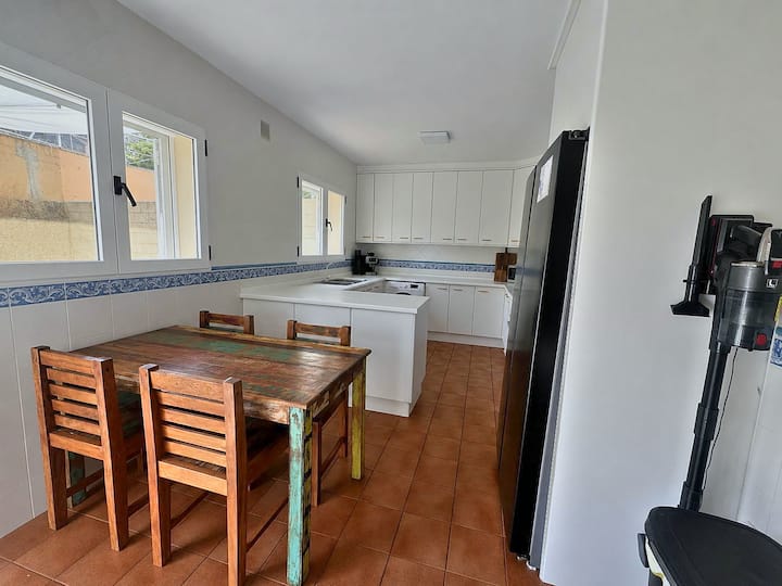 Comedor de la cocina con mesa de madera y nevera con congelador.