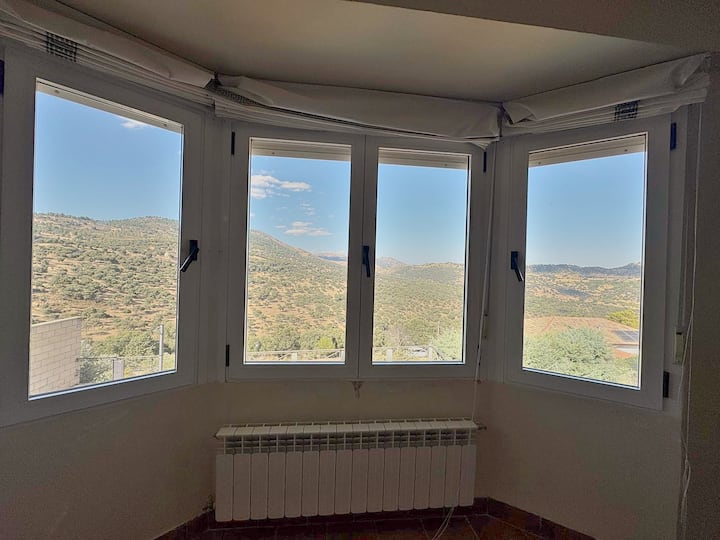 Mirador acristalado al valle, preparado para leer o descansar.