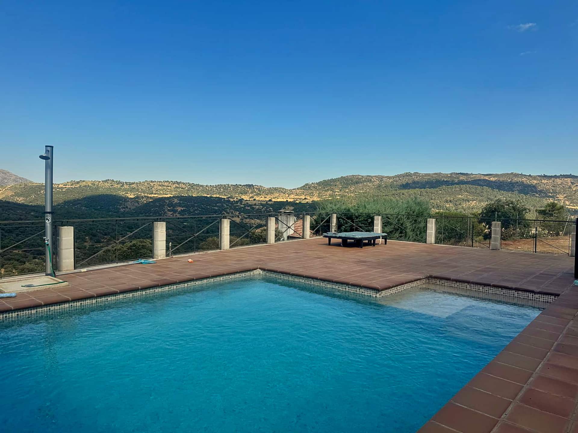 Piscina privada con solárium y vistas abiertas a la sierra.