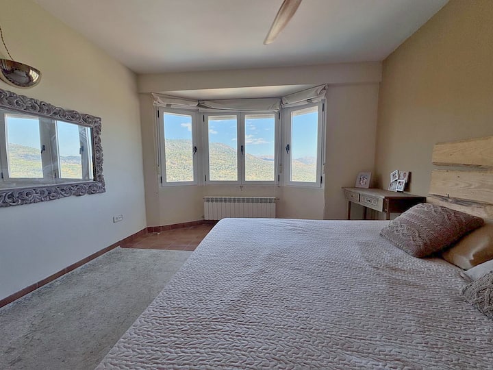 Dormitorio principal con mirador de ventanas y mucha luz natural.