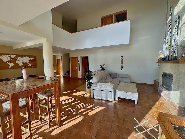 Salón de doble altura con sofás para compartir tiempo en grupo.