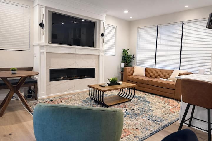 Sala de estar moderna con chimenea, televisor grande y cómodos asientos elegantes