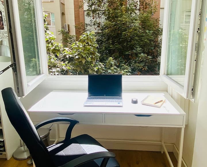 Zona de trabajo junto a la ventana y el arbolado.