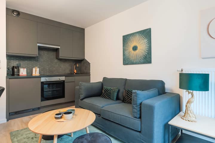 Una acogedora sala de estar con sofá cama, televisión, mesa auxiliar y mesa de comedor ideal para sus comidas y para guardar sus cosas.
