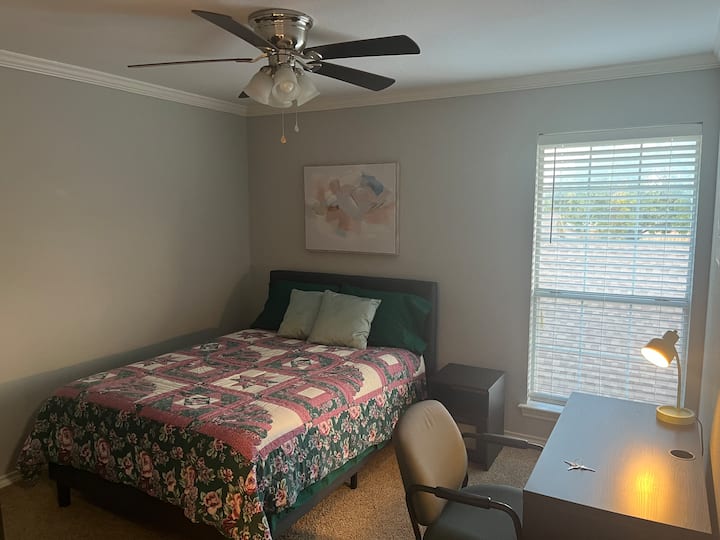 Secondary Bedroom - furnished with double bed with linings, blanket,  bedspread, & pillows, tall dresser, desk, chair, nightstand, and decor items.  Room has a large walk-in closet.