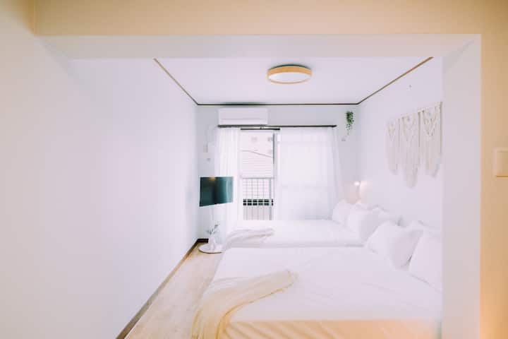 Room with two beds and wall-mounted TV