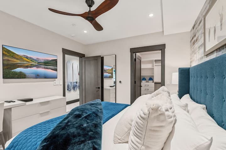 Chambre 2 : très grand lit, télé connectée, fenêtres du sol au plafond, salle de bain attenante