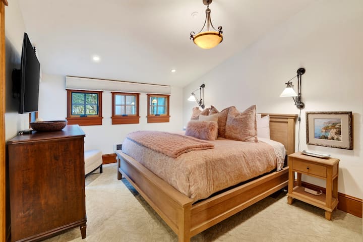 El dormitorio principal cuenta con una cama tamaño king, TV y baño privado para disfrutar de un cómodo refugio privado.