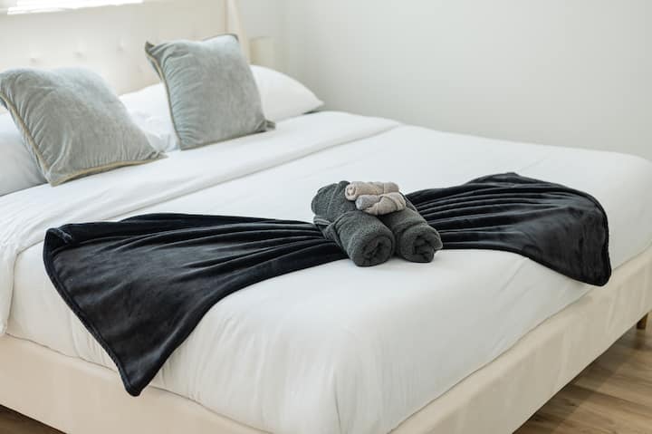 Sumérgete en una cama con ropa de cama suave y disfruta de una noche de sueño tranquilo en este luminoso y cómodo dormitorio de invitados.