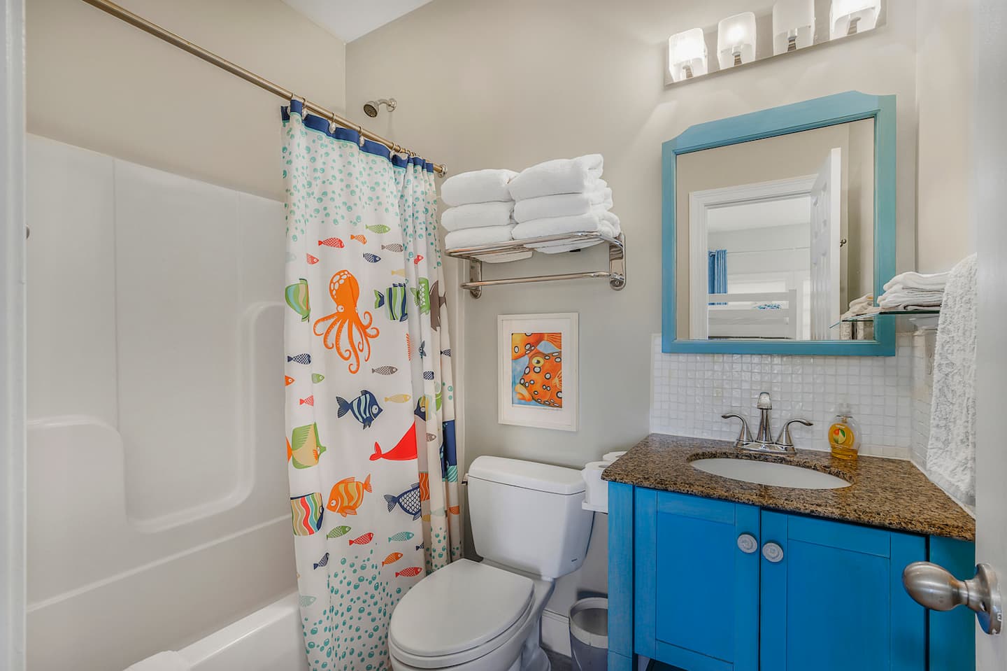 Let the kids splash in a tub with an octopus on the curtain: their own bath, right next to the bunk room, so bedtime routines don't cross paths.