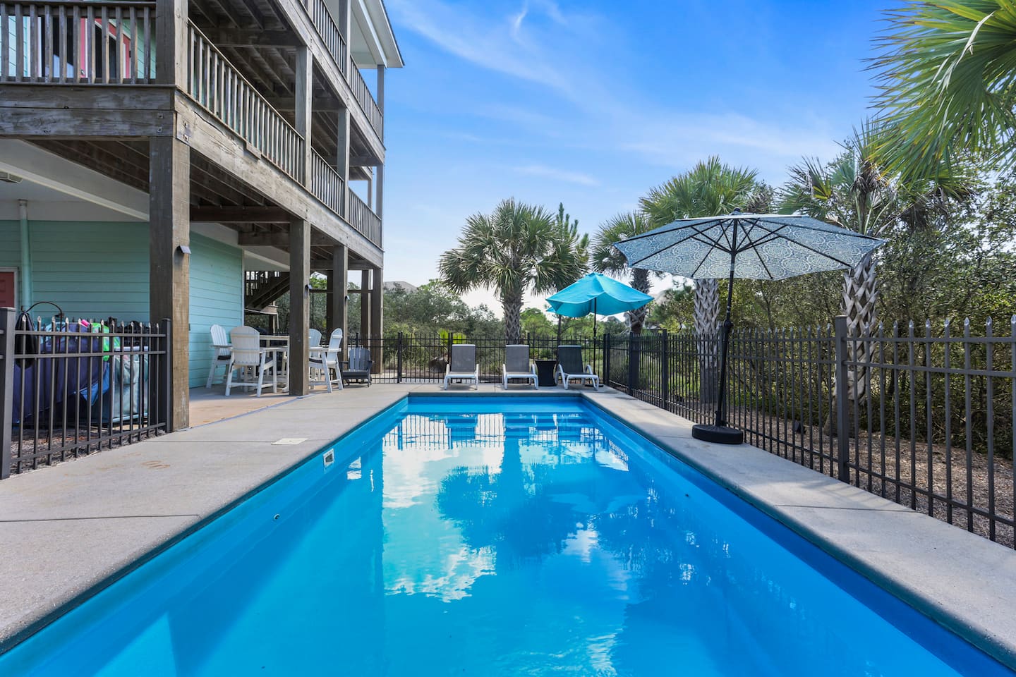 Float on your back and look up at sky: the whole house watching over the pool. Ten laps or zero, nobody's keeping count.