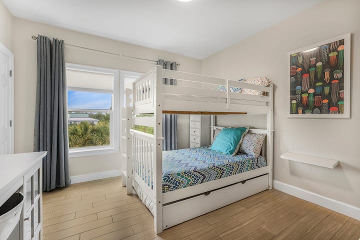 Send the kids up the ladder and pull out the trundle for one more: three beds in one room means the grown-ups get the quiet floors. Sleeps 10 without anyone on a couch.