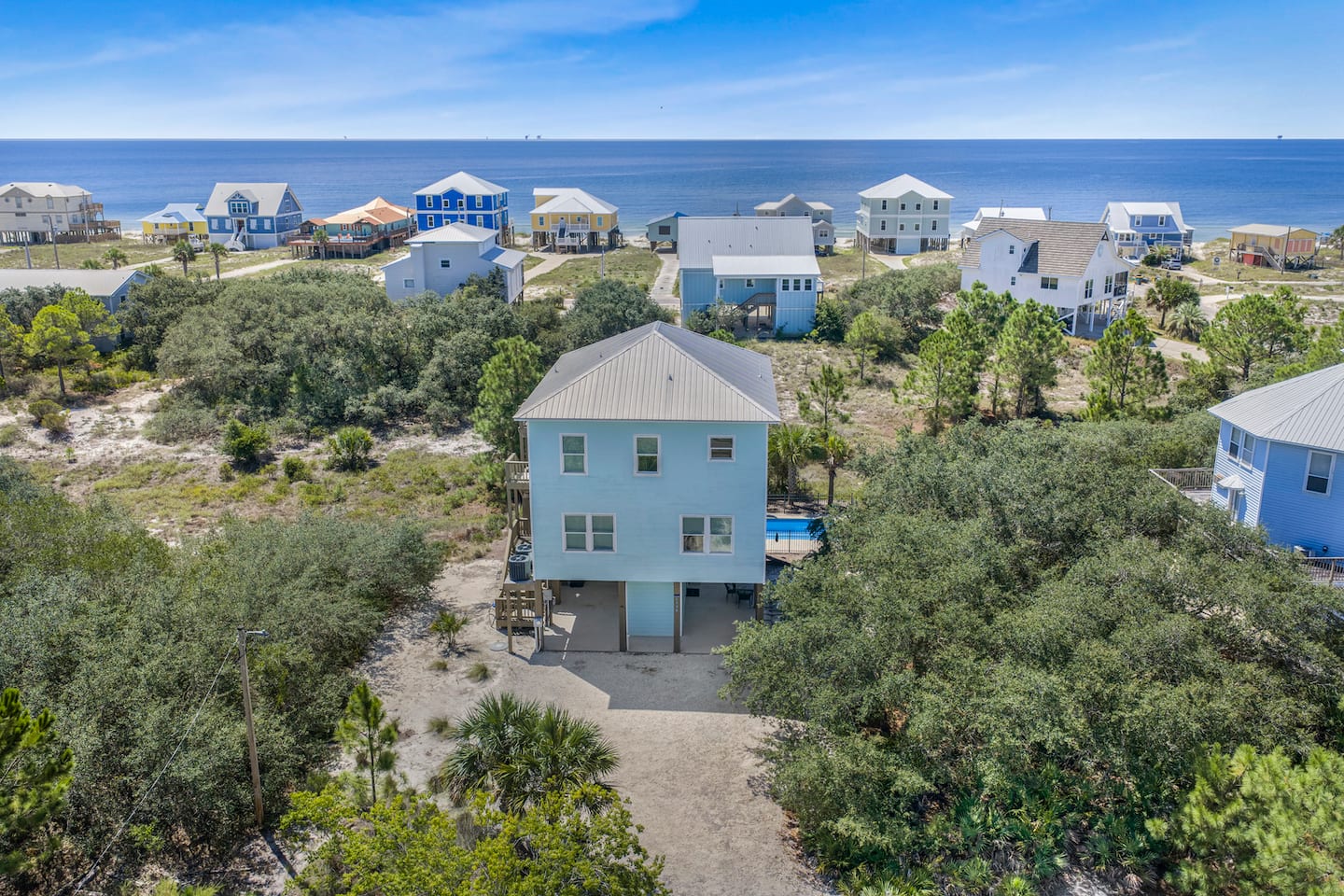 Count the rooftops between you and the water: that's the walk to the beach. Your house sits right there in the middle of it, pool tucked underneath.