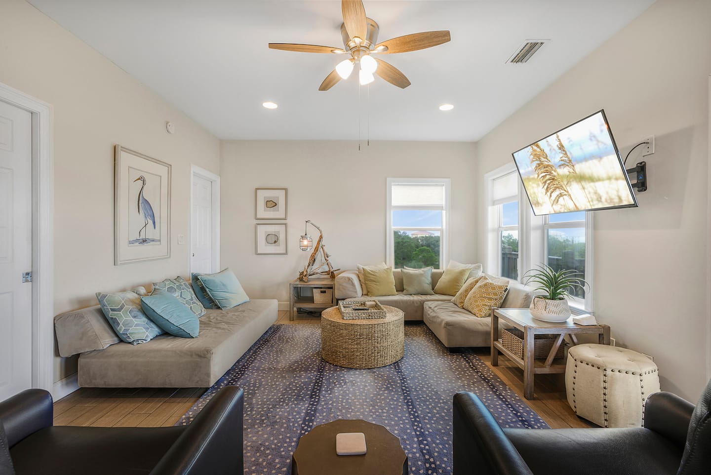 Recline, put your feet up, and let the ceiling fan do its thing: seating for the whole crew, a wall-mounted TV, and the deck a step away.