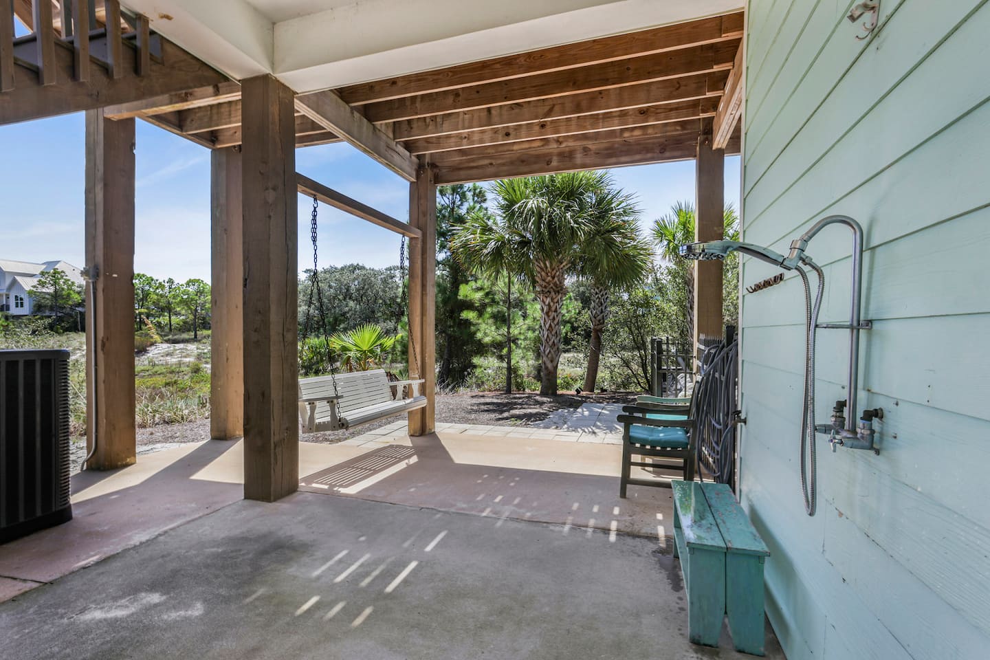 Rinse the sand off in the outdoor shower before you ever touch the stairs, then take the porch swing while your suit drips dry.