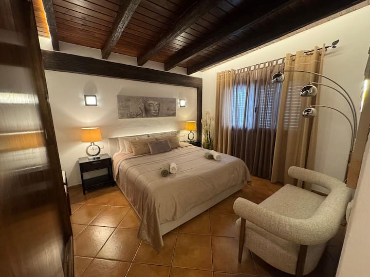Dormitorio principal con cama matrimonial y baño en suite
