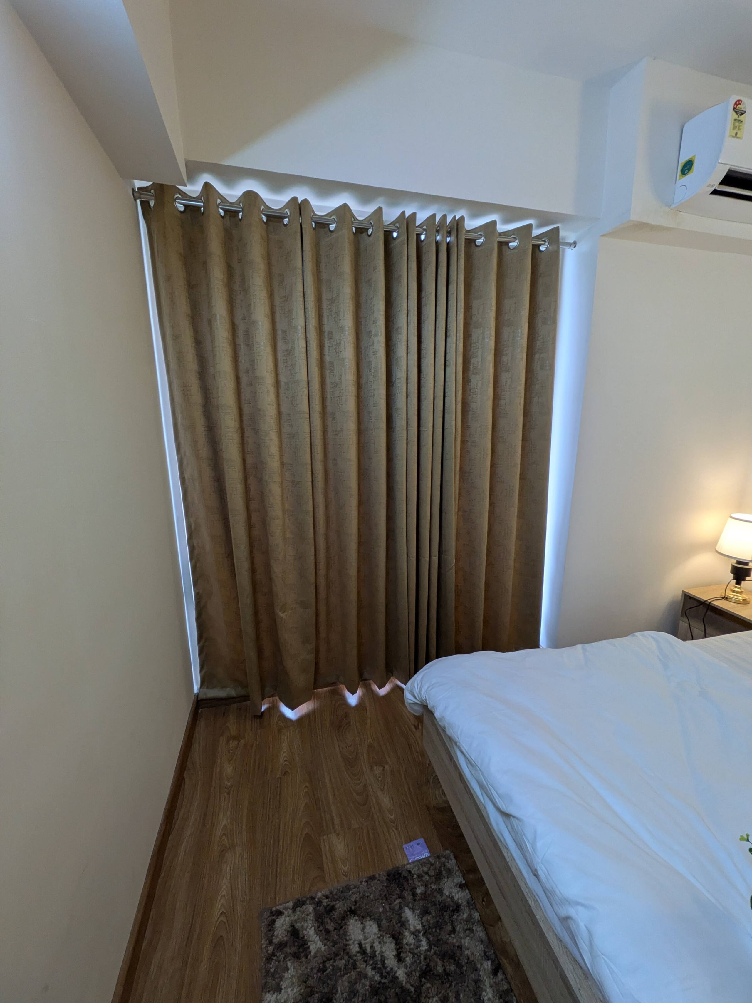 Bedroom one beside a curtained window