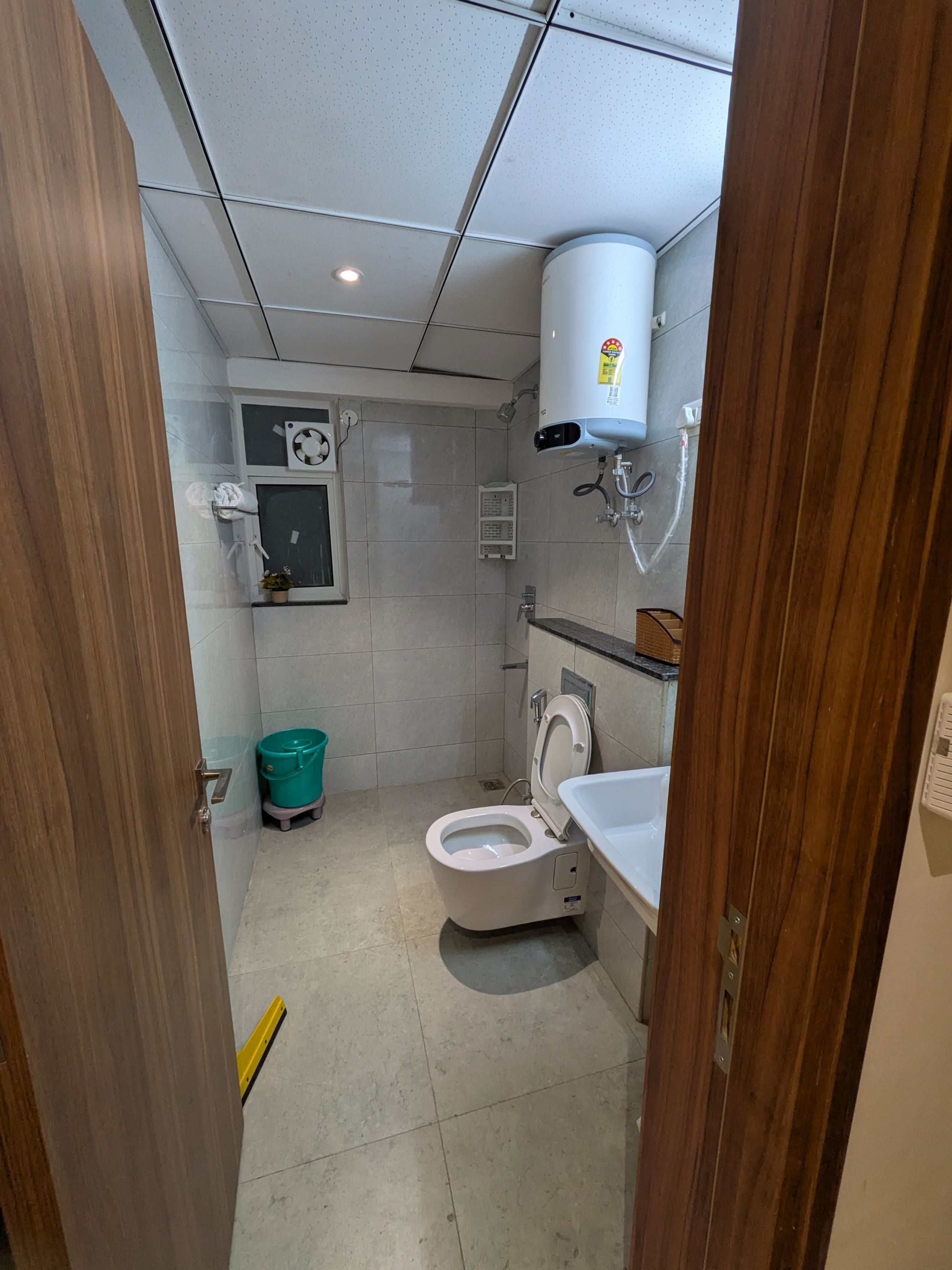 Bathroom with geyser seen through the doorway