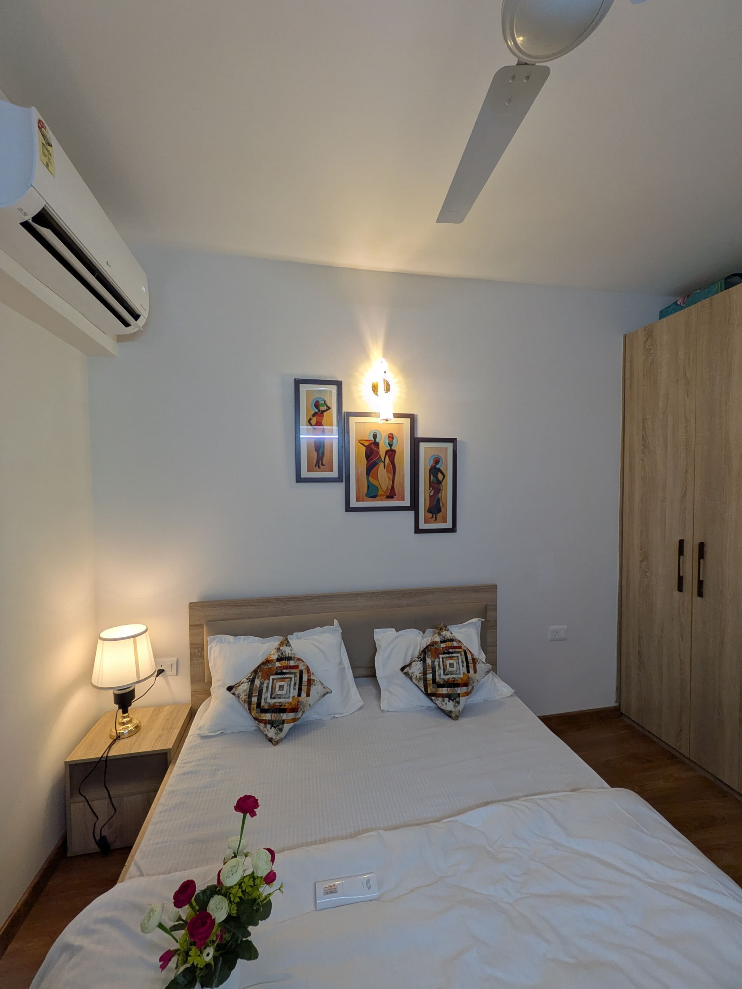Bedroom one with crisp white linen and framed art