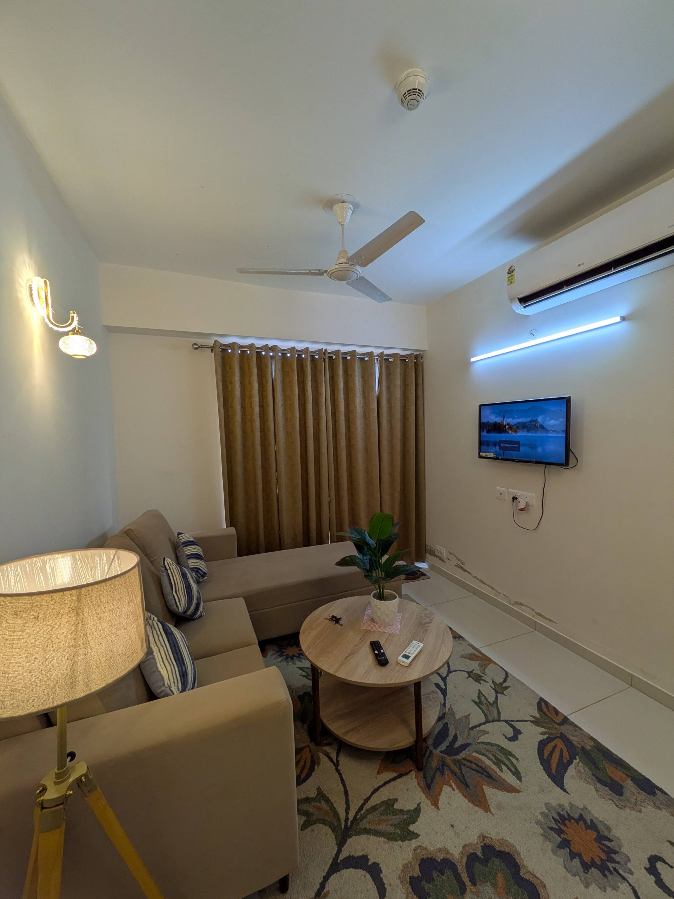 Elegant Suite living room with sofa, round coffee table, TV and curtains