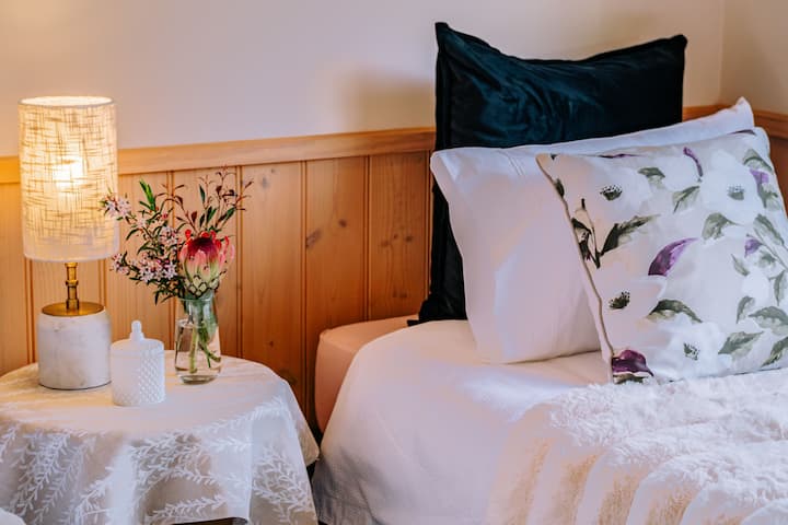 Dos camas individuales con una mesa de noche compartida, lámpara de lectura y flores frescas del jardín. 
Ropa de cama cómoda y sábanas lujosas.
