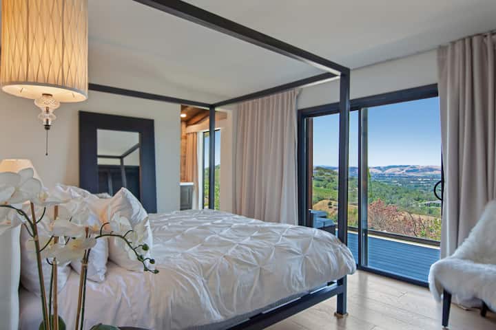 Bedroom 2: King canopy bed with new memory foam mattress, full ensuite bathroom with floor to ceiling windows, walk out deck to valley views, located on second (middle) floor.