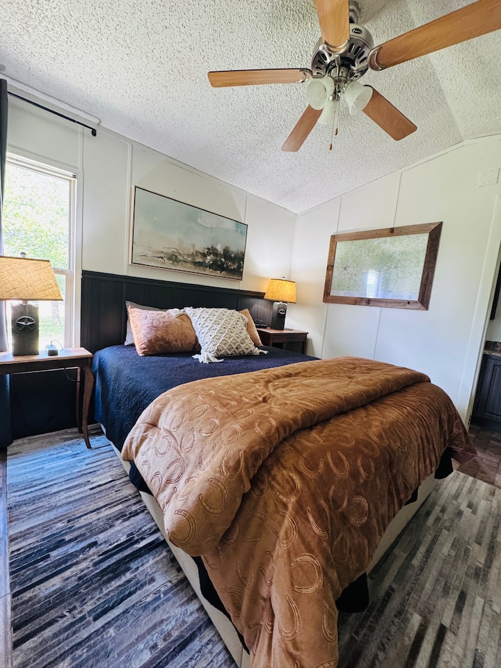 A queen bed under blackout curtains, designed for two and built for late mornings.