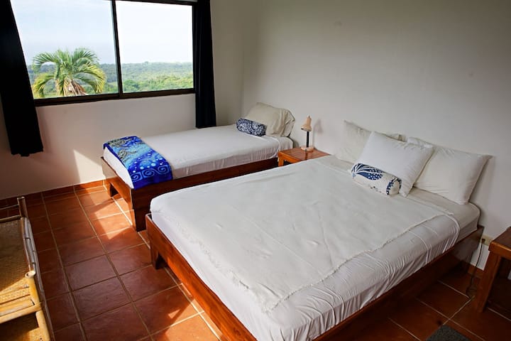 A queen sized bed and a twin bed in this spacious second floor East/South facing windows.   Expansive views!  This room has A/C