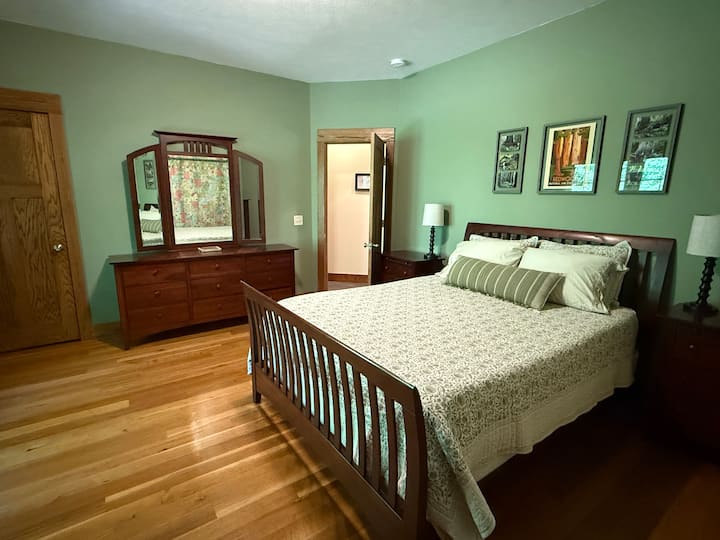 ห้องนอนชั้นล่างพร้อมเตียงควีนไซส์และห้องนอนติดกัน