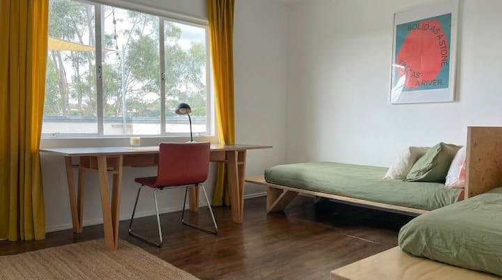 Two twin beds and a large Enzo Mari–style desk share the room with ease. The beds can double as seating for meetings or lounging, while the desk sits front and center by the window with views over Silver Lake.