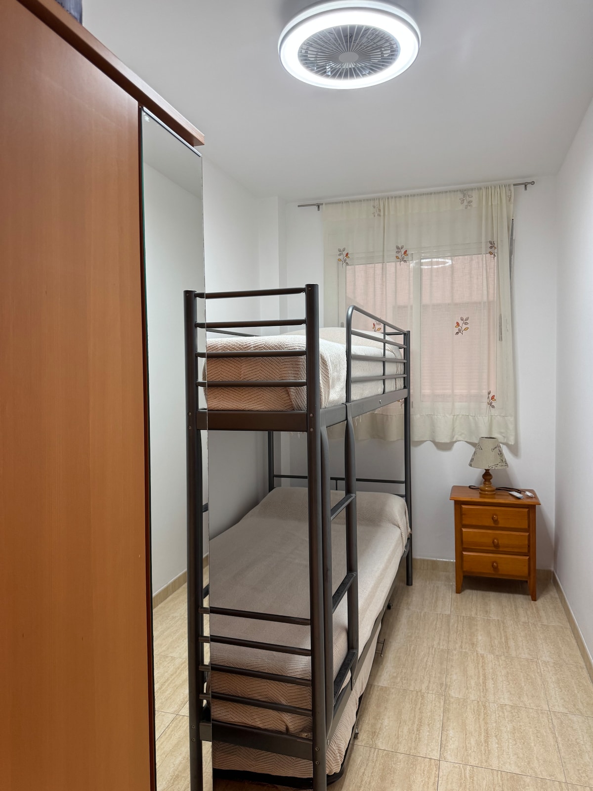 غرفة نوم ثانية مع سرير بطابقين قوي للغاية وسرير إضافي مع قاعدة سرير بعجلات تحته. مروحة مع مصباح LED مدمج في السقف 